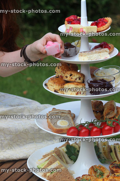 Stock image of afternoon tea / cream tea, tiered cake stand, sandwiches, cakes, scones