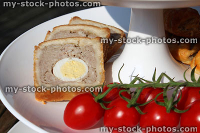 Stock image of afternoon tea, tiered cake stand, egg pork pie, cherry tomato vine