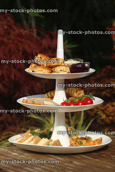 Stock image of afternoon tea / cream tea, tiered cake stand, sandwiches, cakes, scones