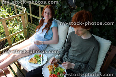 Stock image of children eating alfresco breakfast outside, treehouse deck / decking, wooden garden furniture