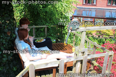 Stock image of children eating alfresco breakfast outside, treehouse deck / decking, wooden garden furniture
