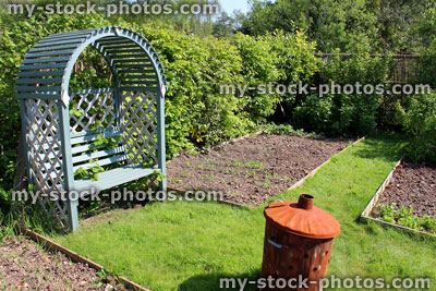 Stock image of allotment vegetable garden with arbor seat and incinerator