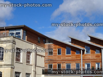 Stock image of historic Bath stone flats and modern houses, timber cladding, sloping flat roofs