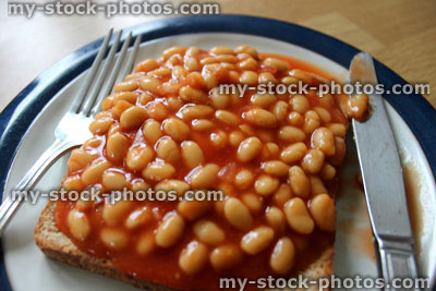 Stock image of baked beans on toast, with knife and fork