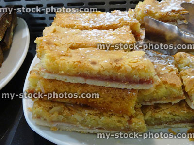 Stock image of almond slices, indulgent dessert, pudding, sifted icing sugar