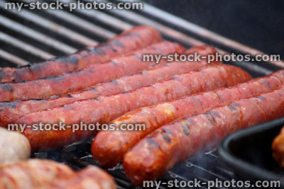 Stock image of charcoal barbecue, garden trolley BBQ grill, sausages cooking