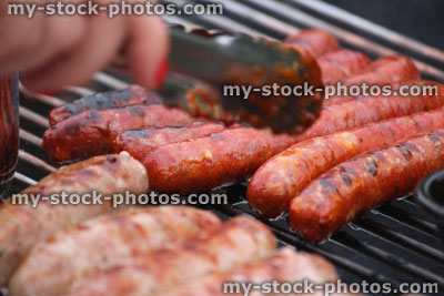 Stock image of charcoal barbecue, garden trolley BBQ grill, sausages cooking