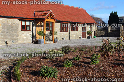Stock image of old barn conversion house / bungalow, converted stables / outbuilding, front garden