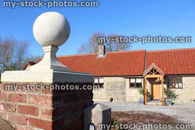 Stock image of red brick gate post, stone ball finial / pier cap, barn conversion bungalow