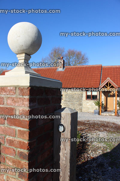Stock image of red brick gate post, stone ball finial / pier cap, barn conversion bungalow