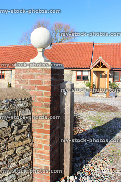 Stock image of red brick gate post, stone ball finial / pier cap, barn conversion bungalow, open porch