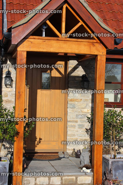 Stock image of gable design wooden open porch and front door / doorstep, security camera
