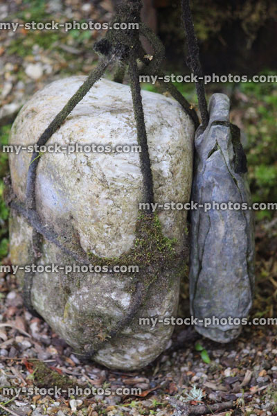 Stock image of barrier stone in Japanese garden, tied with black string