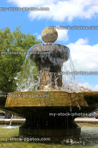 Stock image of old Bath stone fountain with cascading sparkling water in sunshine