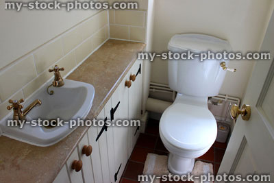Stock image of country style cloakroom toilet, basin and storage cupboards