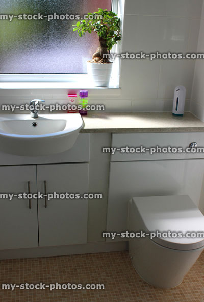 Stock image of stylish white bathroom suite, sink and modern toilet