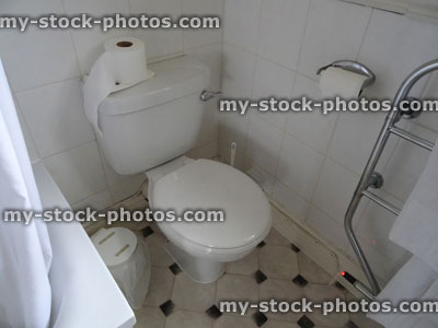 Stock image of old white toilet in bathroom, heated towel rack