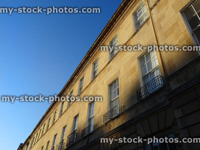 Stock image of historic terraced Georgian houses / Bath stone townhouses against sky