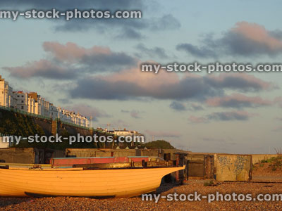 Stock image of sunset on Brighton beach with boats, houses, graffiti