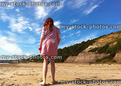 Stock image of girl on Bournemouth beach, with blue sky, cliffs
