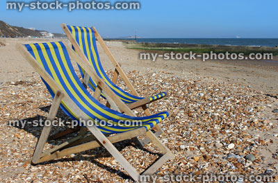 Stock image of blue and yellow striped deckchairs on English beach