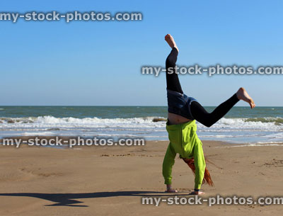 Stock image of girl doing cartwheel / handstand on Bournemouth beach