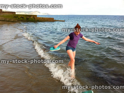 Stock image of girl paddling in sea during summer holiday and getting wet