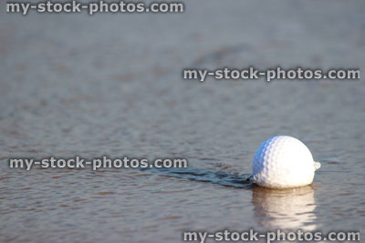 Stock image of beach golf / wet golf ball in water / sea