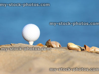 Stock image of golf ball on sandy seaside beach, sea and sand