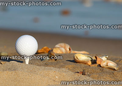 Stock image of golf ball on sandy seaside beach, sea and sand