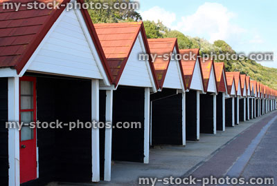 Stock image of black and white painted beach huts at seaside