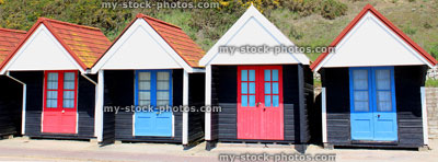 Stock image of banner of colourful English painted beach huts next to cliff