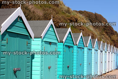 Stock image of colourful English painted beach huts next to cliff