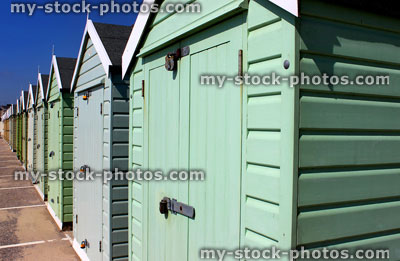 Stock image of colourful English painted beach huts next to cliff 