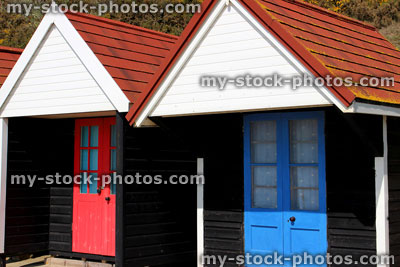 Stock image of colourful English painted beach huts next to cliff