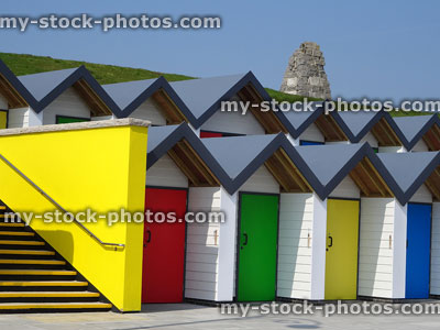 Stock image of white concrete and timber beach huts, seaside promenade