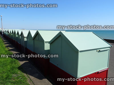 Stock image of row of wooden beach huts, painted duck egg green