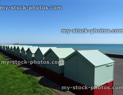 Stock image of green beach huts / painted sheds lining Brighton seafront