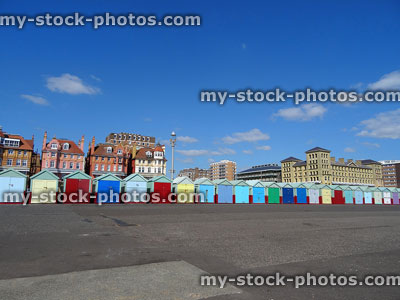 Stock image of brightly coloured beach huts lining Brighton seaside promenade