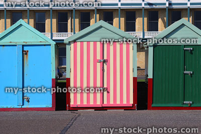 Stock image of Brighton beach huts with retro pink stripes front door