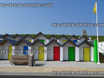 Stock image of white beach huts with brightly coloured front doors