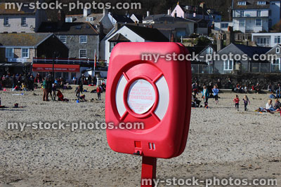 Stock image of lifering buoyancy aid on beach, by sea, for emergencies