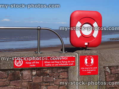 Stock image of seaside lifebuoy / lifering donut buoyancy aid by beach