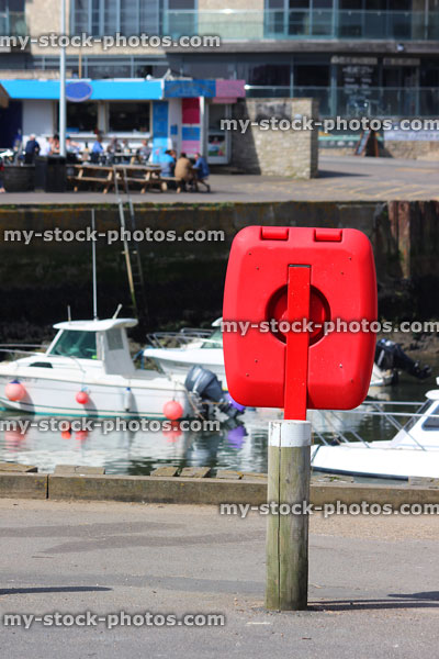 Stock image of marina boats and red lifering donut / life buoy life preserver