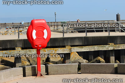 Stock image of life preserver lifering / life buoy donut by seafront harbour