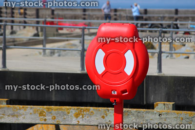 Stock image of seaside lifering / red life buoy donut at harbour