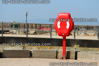 Stock image of red lifering buoyancy aid at seaside / ring buoy
