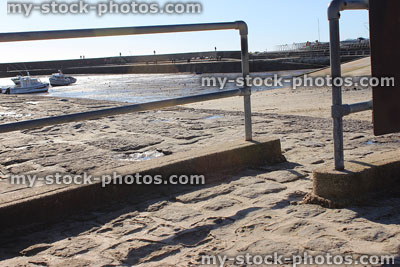 Stock image of cobblestone paving pathway next to sea / harbour / handrail
