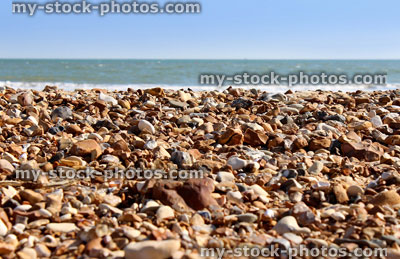 Stock image of pebbles, sand and sea on beach, British seaside