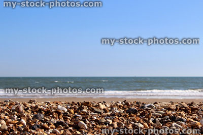 Stock image of pebbles, sand and sea on beach, typical seaside